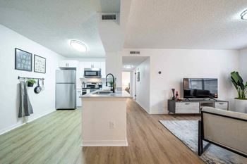 A kitchen with a refrigerator, microwave, and oven.